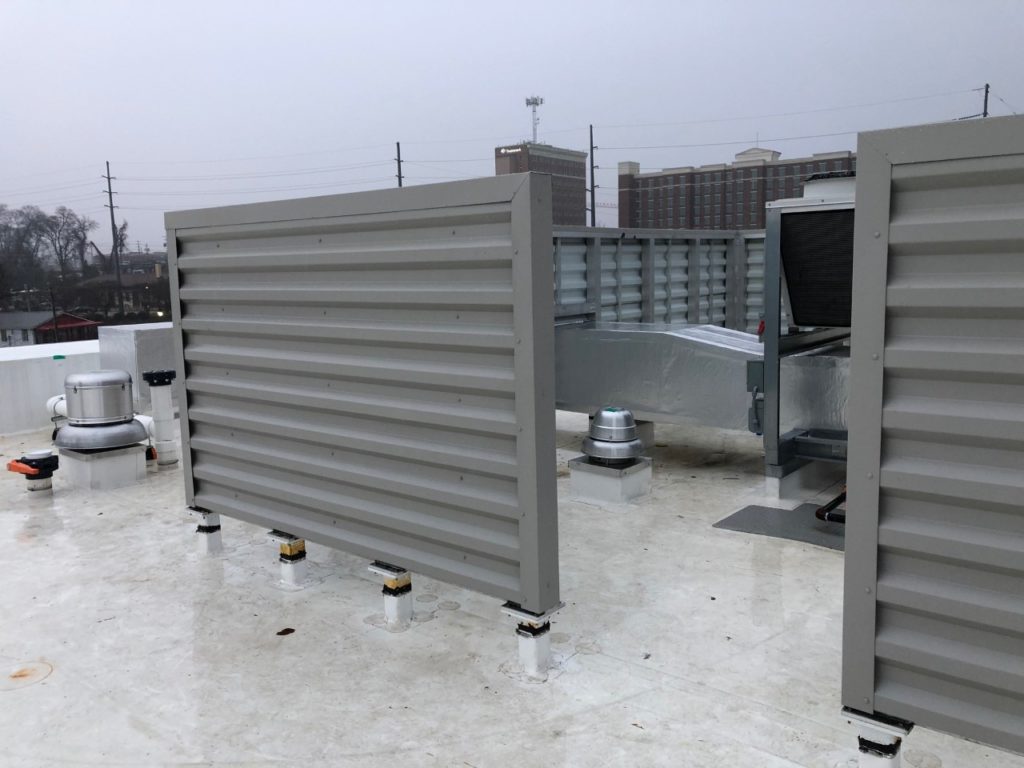 Commercial rooftop with RTU screens and HVAC equipment on a flat roof